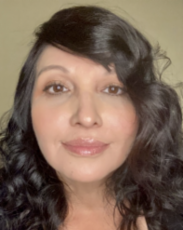 Portrait of a woman with dark, curly hair and a neutral expression.